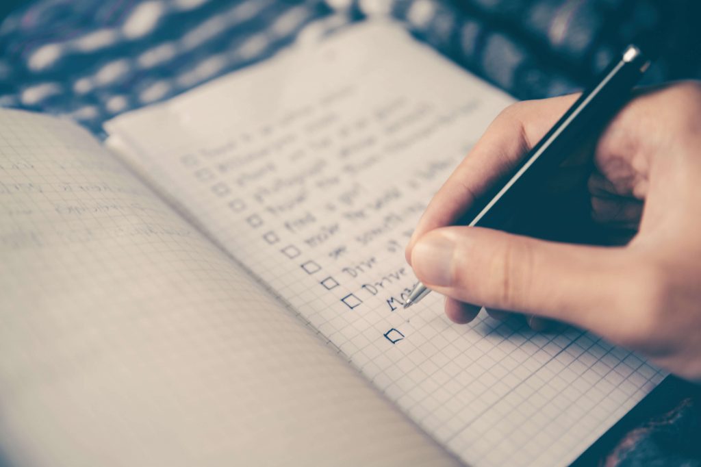 A person making a checklist in a copy
