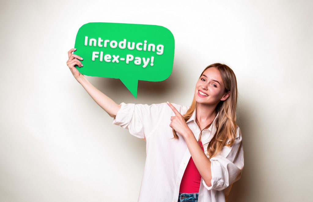 Girl smiling and holding a cardboard and point to card board tell Introducing flex-pay!